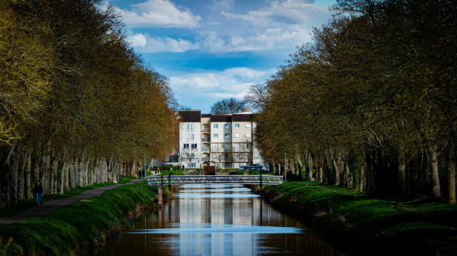 Tree-lined canal in Vierzon, central France, on a mild day outside the peak summer season